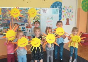 Na zdjęciu widać grupę dzieci trzymającą w rękach wykonane przez siebie słoneczka.
